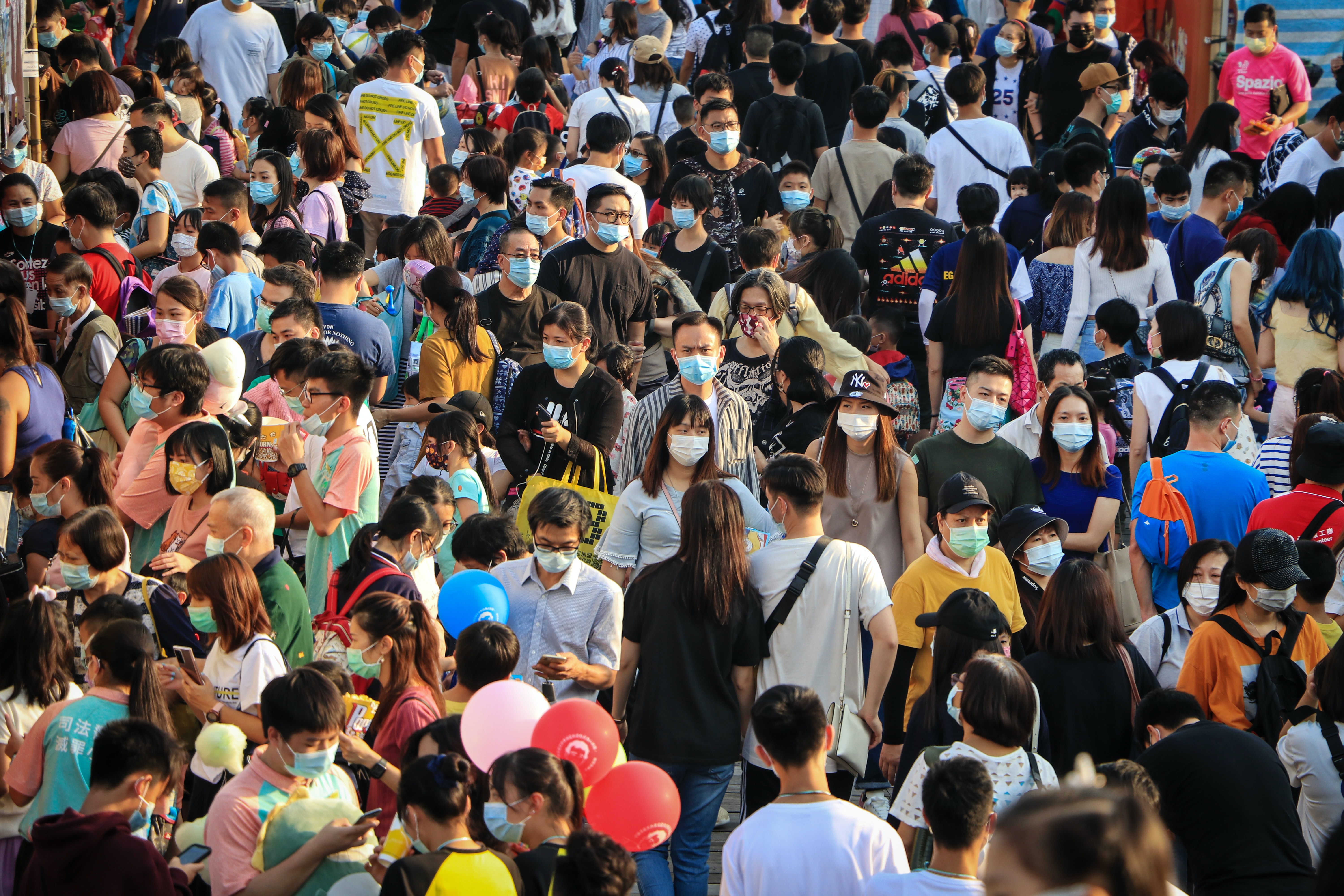 Photo of many people walking in a crowd.